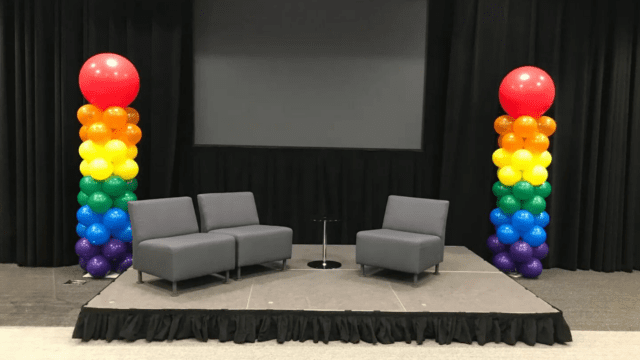 two rainbow colored balloon columns
