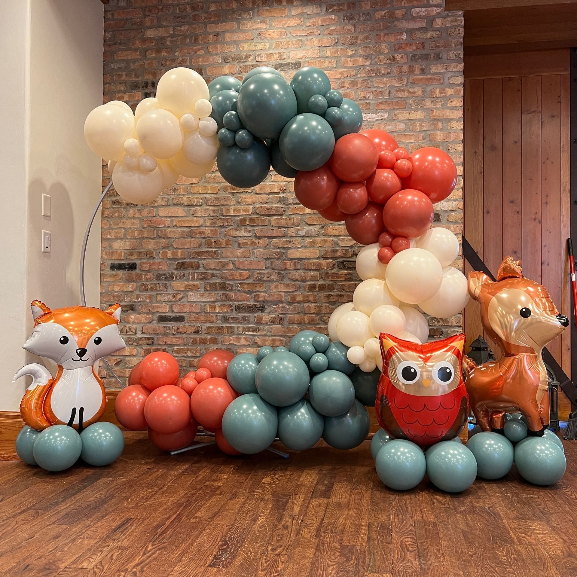 balloon garland backdrop with a fox, an owl, and a deer